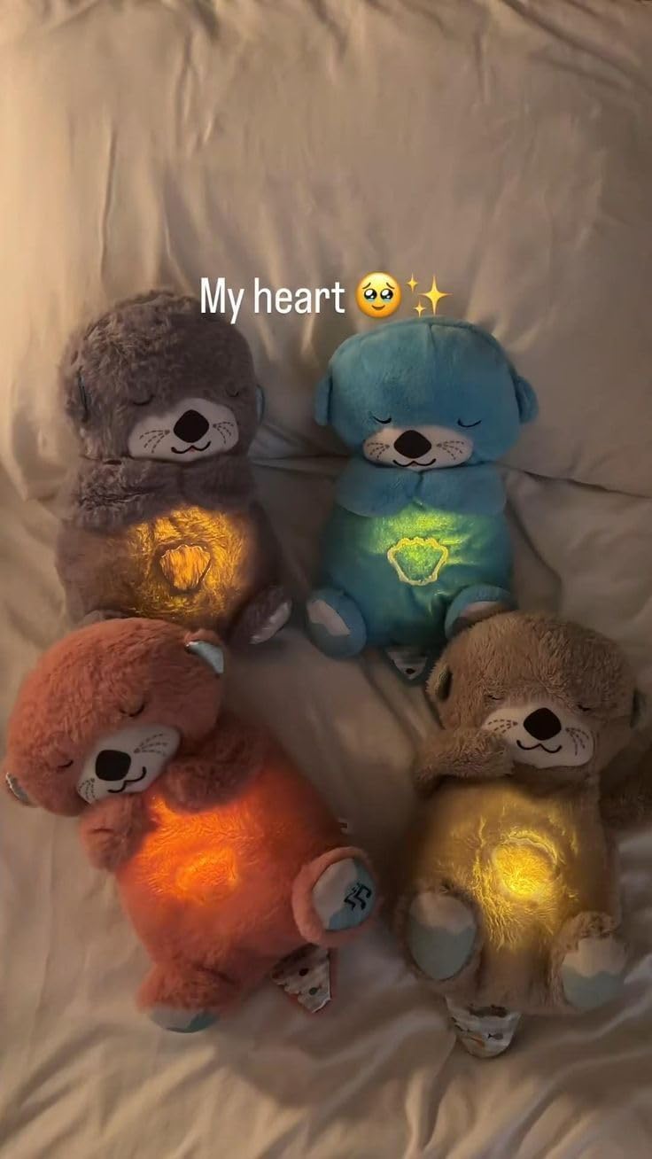 Sleeping teddy bear plush with warm LED heart light placed on a bed at night.